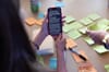 A photo of a phone saying "Artificiality Summit: A Framework Manifesto for Society-Scale Decisions with AI" held above a table covered in stickies. 